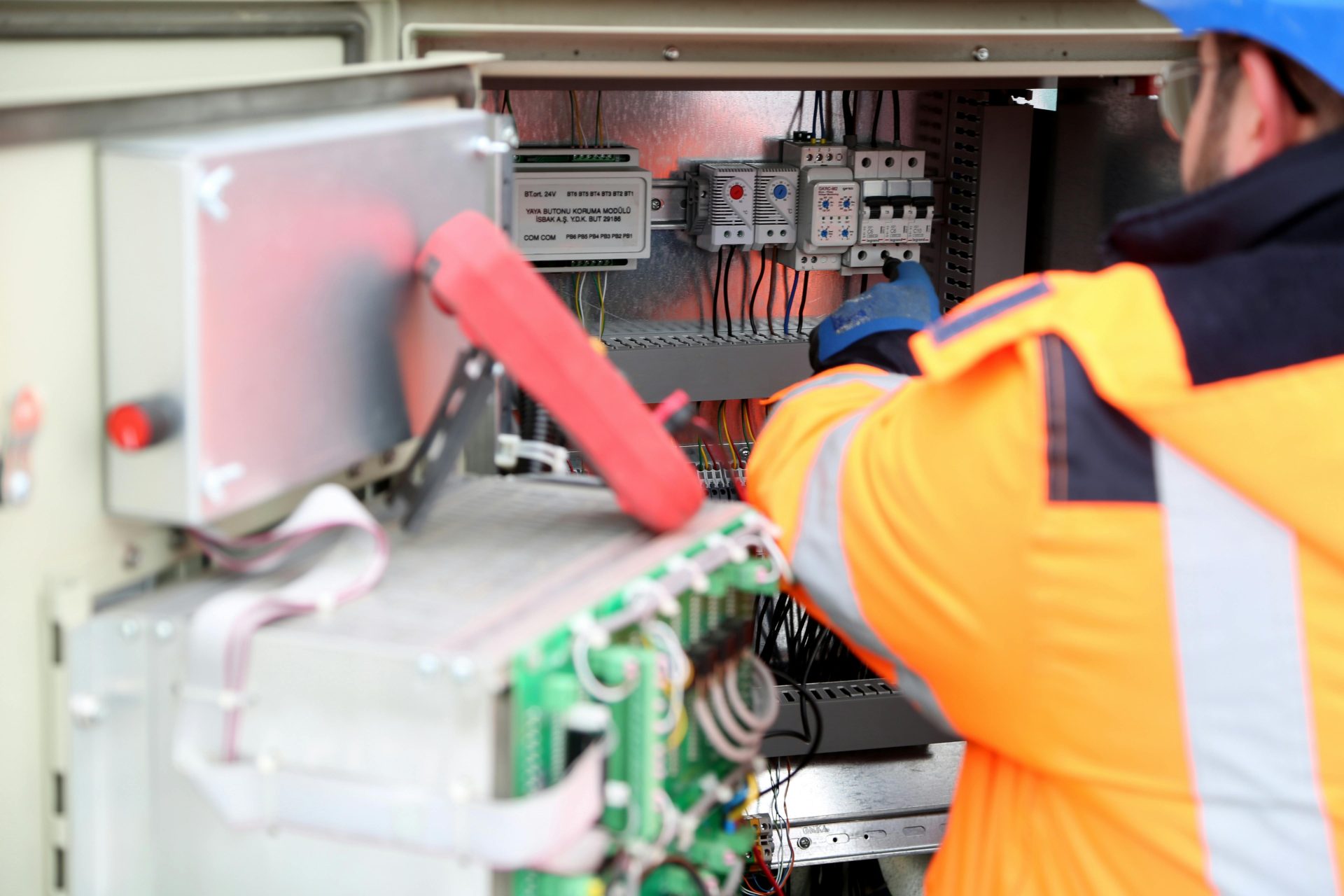 Ein professioneller Ingenieur inspiziert eine industrielle Leiterplatte und stellt dabei die Einhaltung der Sicherheitsstandards sicher.